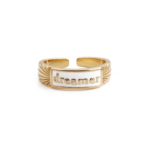 Close-up of gold-plated adjustable ring with white enamel and dreamer engraving