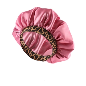 Pink satin hair bonnet with leopard print elastic band shown from 45-degree angle