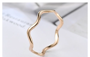 Macro shot of minimalist wave-shaped titanium steel ring in elegant rose gold finish