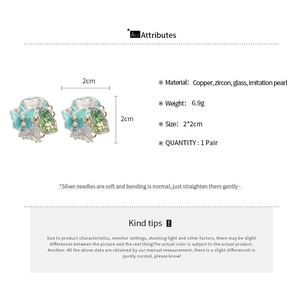 Detail view of butterfly floral earrings with 18k gold plating and pearls, 2x2cm size