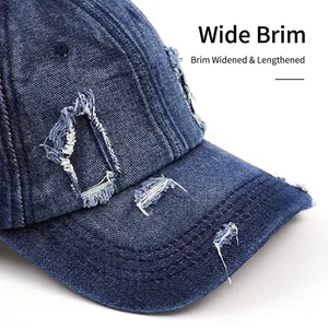 Distressed dark blue denim baseball cap with frayed holes and curved brim for sun protection