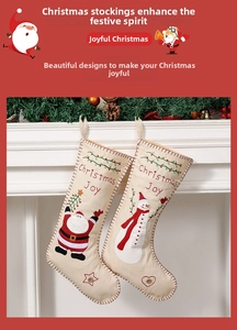 Detail of embroidered Christmas Joy stockings with Santa and Snowman on a fireplace mantle