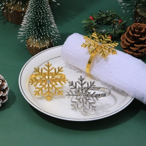 Detailed view of silver and gold snowflake napkin rings set with rhinestones for table decor