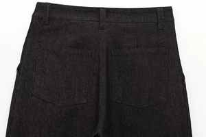 Dettaglio macro dei pantaloni in denim nero con tasche posteriori e passanti
