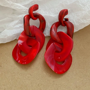 Macro detail of red marble acrylic chain drop earrings with textured resin links