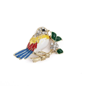 Detailed close-up of a colorful enamel bird brooch with sparkling rhinestones and gold alloy