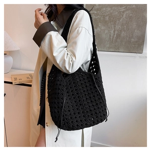 Dettaglio della borsa a tracolla in crochet nero con motivo traforato e coulisse laterale