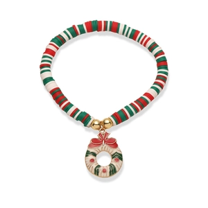 Détail du charm de Noël en émail sur un bracelet de perles en pâte polymère rouge et verte