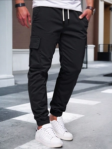 Detail of men's black cargo joggers featuring large utility pockets and drawstring waist
