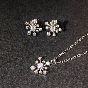 Makroaufnahme von Silberschmuck-Set mit Schneeflocken-Anhänger und Sternschliff-Ohrringen