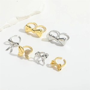 Detailed view of adjustable gold and silver bow rings with sparkling rhinestone accents