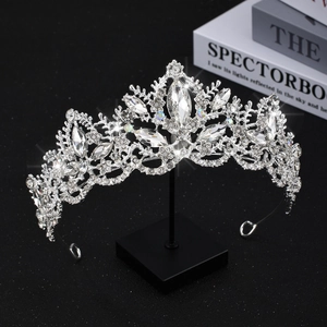 Detail of luxury bridal crown with clear crystals and vine patterns on a display stand