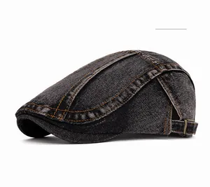 Detail of black washed denim beret featuring orange contrast stitching and adjustable buckle