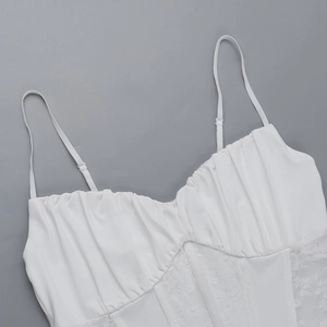 Detail of white lace stitching, thin shoulder straps, and corset waist on a sexy top