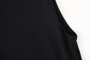 Detailed close-up of black knitted fabric texture and premium stitching on padded shoulder dress