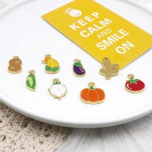 Set of eight colorful enamel vegetable charms including corn, pumpkin, and tomato charms