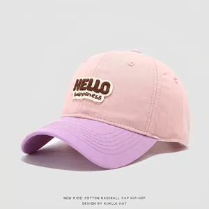 Detail of Hello Happiness embroidery on a pink and purple cotton baseball cap for kids