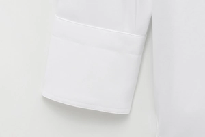 Detail of white twill shirt cuff showing precise double stitching and premium fabric texture