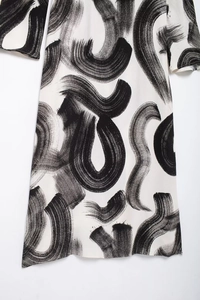 Detail showing the abstract brushstroke print and lightweight fabric of the dress