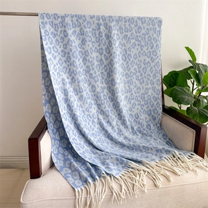 Close-up of blue and beige leopard print cashmere-like scarf with fringe on a chair