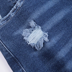 Detailaufnahme von blauem Denim mit distressed Textur und ausgefranstem Riss am Saum