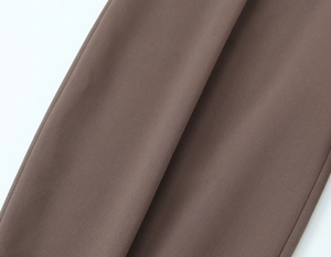 Vue macro du tissu tissé marron foncé montrant la texture détaillée du blazer