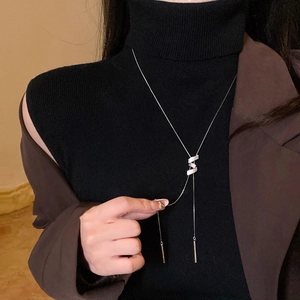 Primo piano di una collana a Y d'argento con ciondolo in zircone indossata da modella