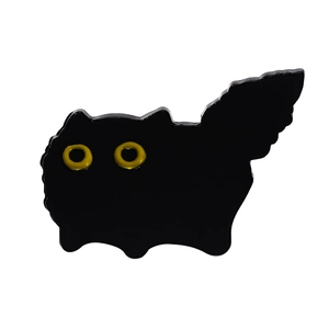 Detailansicht einer glänzenden schwarzen Katzen-Emaille-Anstecknadel mit gelben Augen