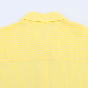 Dettaglio del retro di una camicia a righe gialle che mostra lo sprone e il colletto in cotone