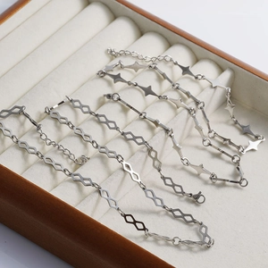 Close-up of silver hollow rhombus and four-pointed star stainless steel chain links