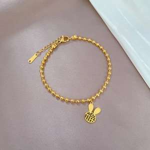 Dettaglio del bracciale a sfere dorate con ciondolo a coniglio e incisione Fu