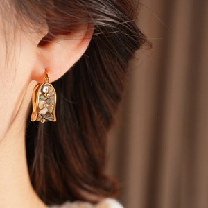 Detailed macro shot of vintage U-shaped earrings with colorful mother-of-pearl inlay