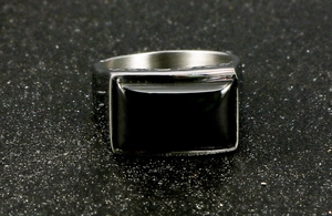 Detailed close-up of men's wide stainless steel ring featuring a black rectangular stone