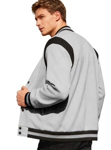 Detail of grey varsity jacket with black shoulder panels and striped ribbed cuffs