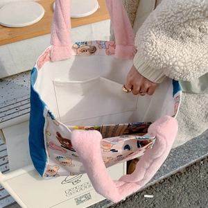 Detail view of canvas tote featuring pink plush handles and colorful cartoon bear patterns