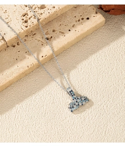 Detailed view of the gradient blue fish tail pendant with crystals on natural stone slabs
