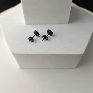 Close-up of black 316L stainless steel disc stud earrings with butterfly backs