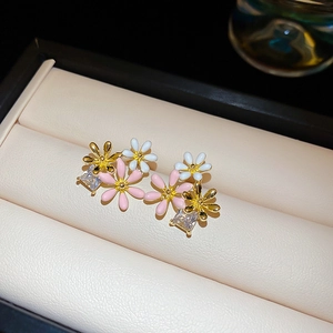 Detail of floral earrings with pink and white petals and square cubic zirconia stones