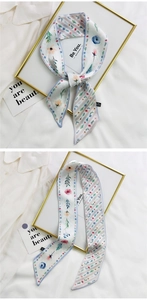 Close-up of floral silk headband with light blue edges and elegant knot detail