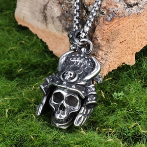 Gothic skull pendant in vintage silver steel with crown detail on wood and moss background