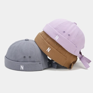 Detail of vintage docker hats featuring embroidered letter N and metal eyelets