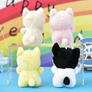 Set of four colorful plush kitten keychains viewed from the back on a clear display stand