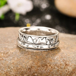 Vintage oxidized silver mountain relief ring on natural stone showing rustic outdoor style