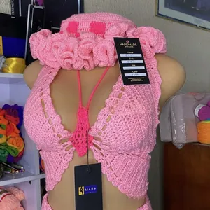 Detailed close-up of handmade pink crochet halter bikini top and ruffled beach sun hat