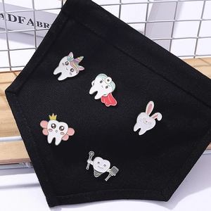 Set of 5 cartoon enamel tooth pins including unicorn and superhero tooth on black pocket