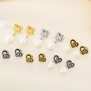 Detail of vintage heart knot earrings in gold and silver with pearls and enamel