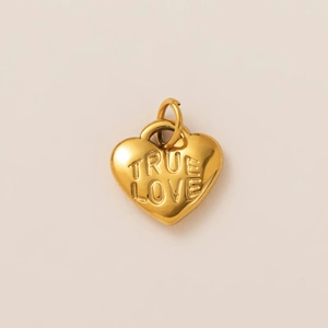 Dettaglio di un ciondolo a cuore placcato oro 18K con incisione TRUE LOVE e finitura liscia