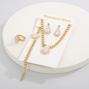 Detail view of a 4-piece gold stainless steel jewelry set with teardrop shell pendants