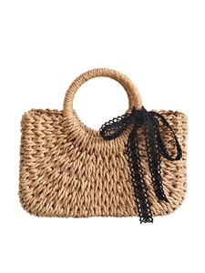 Handwoven straw tote bag with black lace bow decoration in a natural khaki summer style