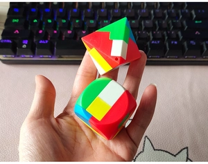 Close-up van kleurrijke piramide en kubus puzzels die met de hand worden vastgehouden